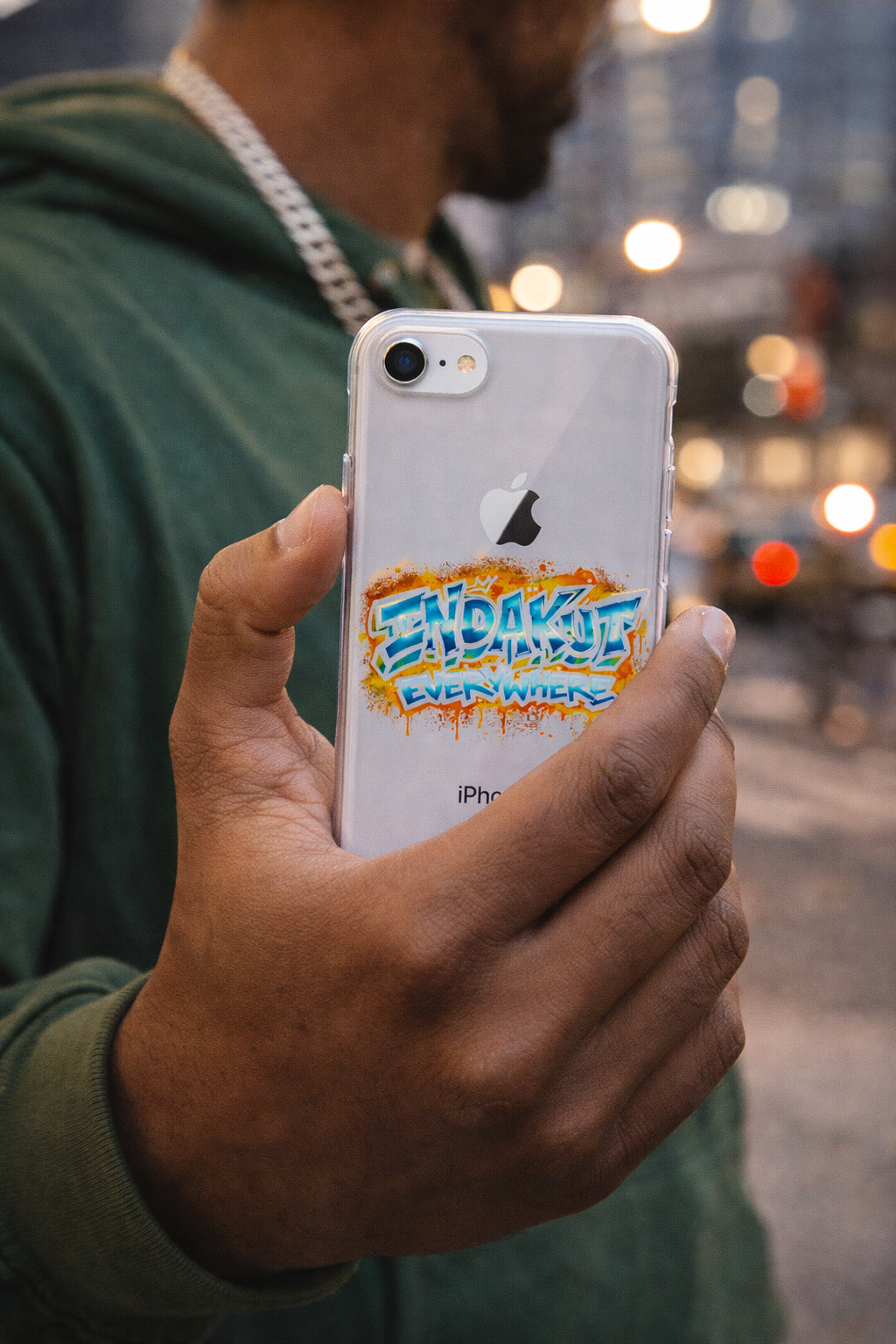 Indakut Everywhere iPhone case with graffiti logo design held in hand in urban street setting