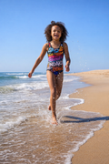 Indakut Everywhere kids swimsuit with graffiti all over print worn at beach in active lifestyle setting