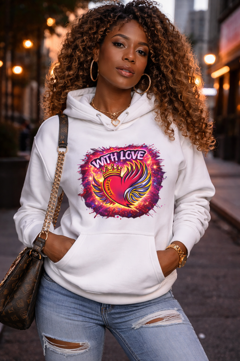 Woman wearing white With Love Always graphic hoodie with heart and wings design in city street setting