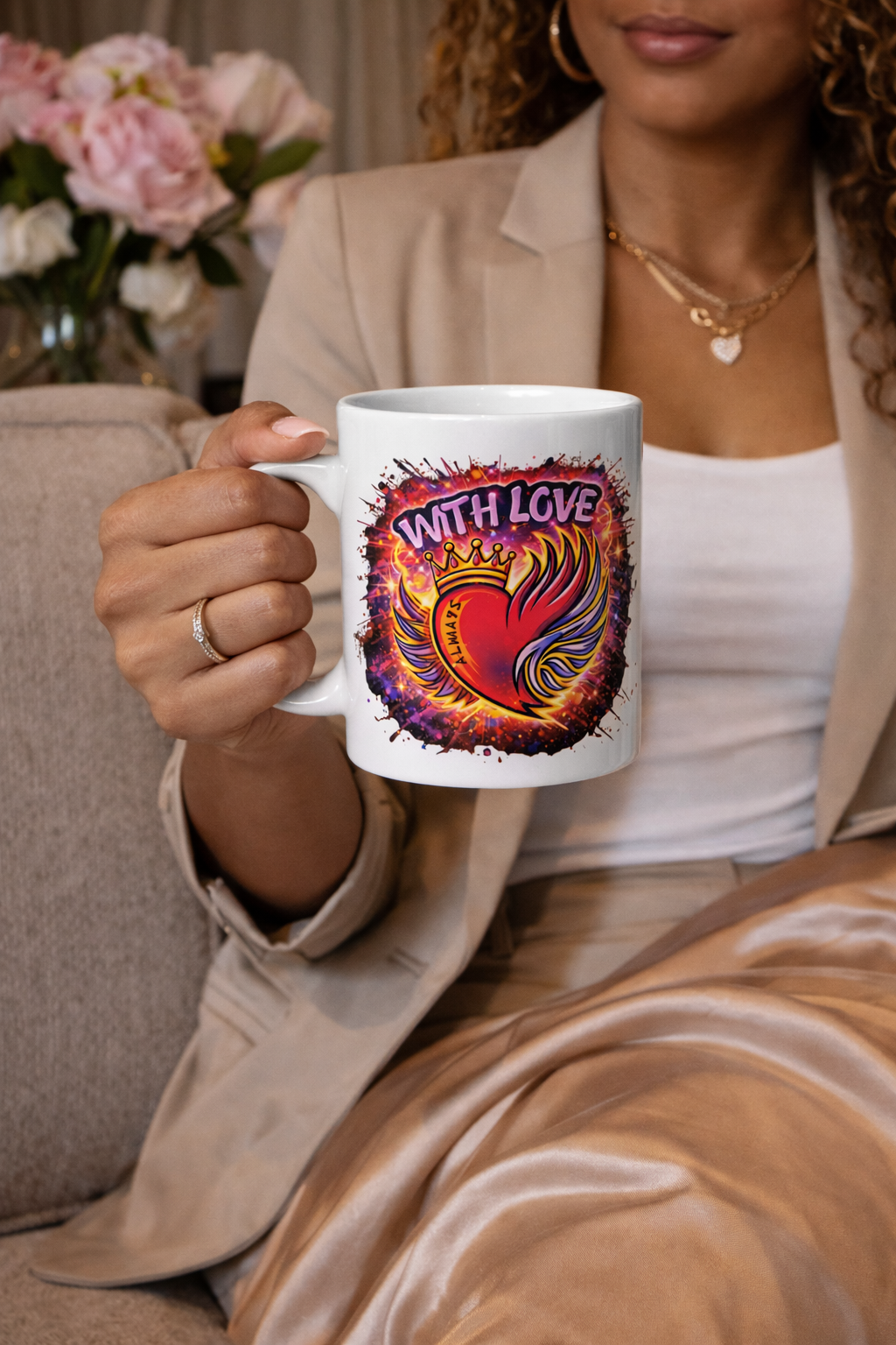 Woman holding With Love Always graphic coffee mug with heart and wings design in cozy indoor setting